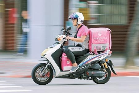 近期發生多起美食平台外送員車禍傷亡事件,外送員的意外險及勞健保等議題引發大眾關注。圖為在馬路上奔馳送餐的 foodpanda 外送員。(本報資料照片)