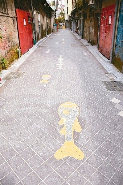 台中市西區華美街與忠誠街是全市首波完工的後巷美化工程,由插畫家在地面彩繪魚兒洄流意象,象徵汙水不再排入河川。 圖/台中市政府提供