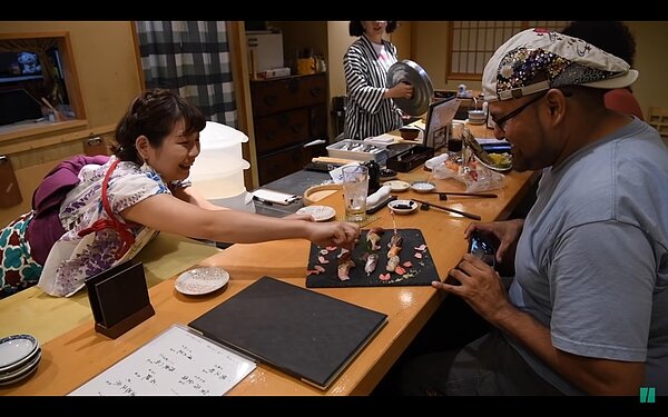 撫子壽司店長的和服袖口沾上壽司的料理台,引起網友對於衛生與服裝方面的質疑,掀起網友與店家之間的論戰。圖/取自Youtube