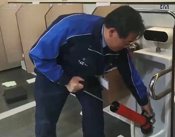 日本專家示範用貫通器抽取小便斗內的尿垢。照片台鐵提供