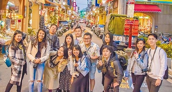 網紅漫步大稻埕商圈兌換「無限暢遊卡」贈送大稻埕大禮包。圖/北市觀傳局提供