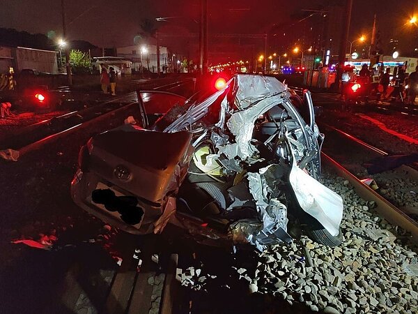 台鐵自強號22日晚行經台中市新烏日站與成功站間的登寺巷平交道時,撞上一輛銀色轎車,女駕駛受傷送醫,造成雙線中斷2個多小時。圖/台中市消防局提供