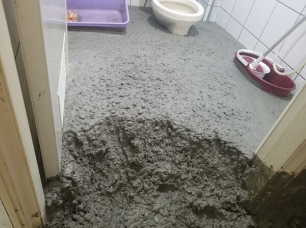 廁所災情慘重，水泥漿快要淹到跟馬桶座同高。圖／取自爆怨公社