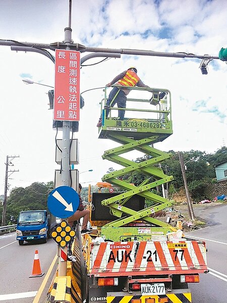 桃園市政府交通局在龜山區試辦區間平均速率執法，工程人員近日在出入口安裝明顯標誌，提醒用路人注意。 圖／桃園市政府交通局提供