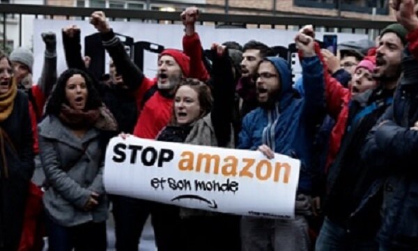 好幾十名示威者在29日黎明時，聚集在亞馬遜的巴黎總部前門靜坐抗議，並且舉著「向亞馬遜和其世界說不」的標誌。圖／臉書專頁Attac France (Officiel)