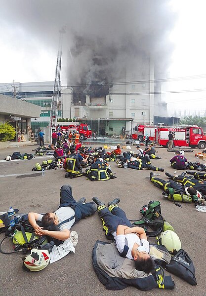 警消過勞超時工作,大法官要求修法,圖為桃園市敬鵬大火,徹夜未眠的消防隊員累得席地而睡。圖/中時報系資料照