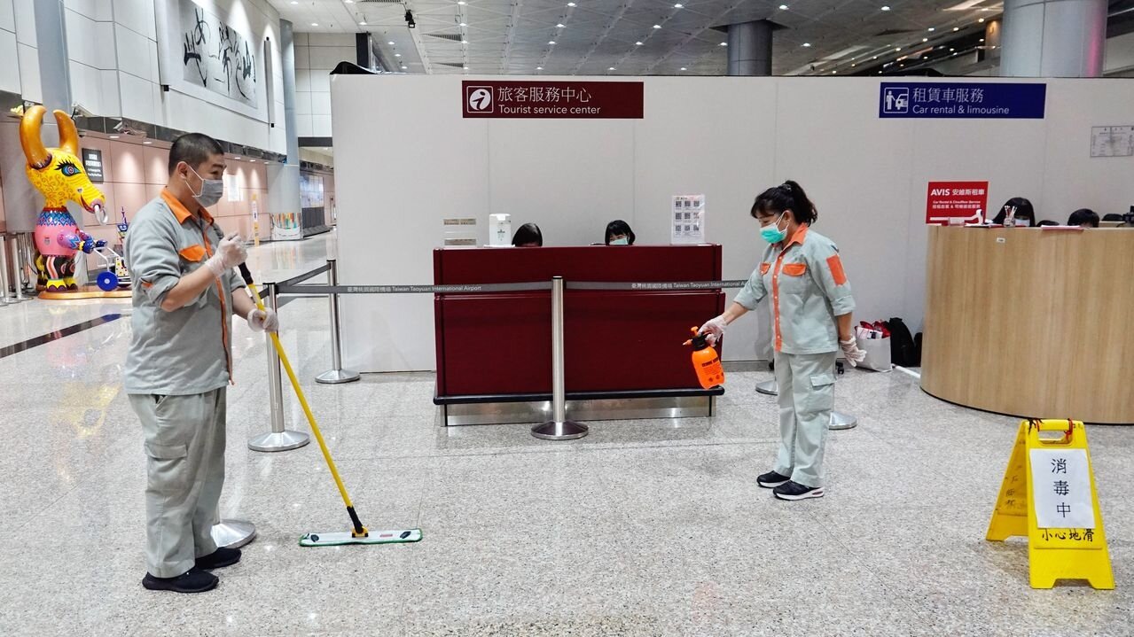 桃機旅客服務中心員工確診,感染源指向也確診的觀光局主管兒子。圖為清潔人員在服務中心櫃台前消毒。記者鄭超文/攝影