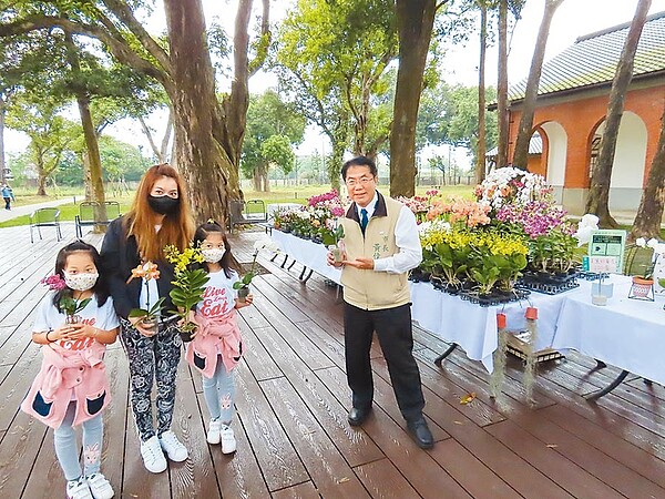 台南市長黃偉哲(右)2日到山上水道花園博物館視察景點實名制施行狀況,與民眾拍照合影時,特別示範在室外應保持的安全距離。(莊曜聰攝)