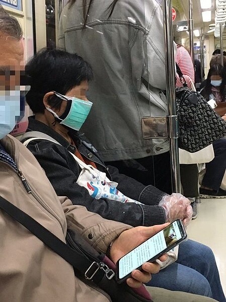 婦人搭捷運戴三層口罩+手套。圖/讀者提供
