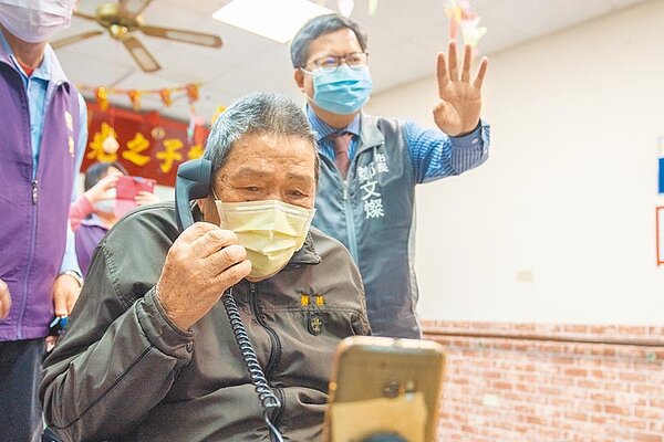 桃園市長鄭文燦訪視長照中心了解防疫狀況,特別陪79歲的劉桂視訊,與家人話家常。(蔡依珍攝)