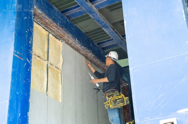 工作人員在玻璃棉外側再覆蓋纖維水泥板，完成複合式分間牆試體。照片國產實業提供