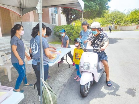 雲林縣18日統一舉行小一新生報到，斗六市鎮南國小採「得來速」報到方式，家長騎摩托車或開車都不用下車。（周麗蘭攝）