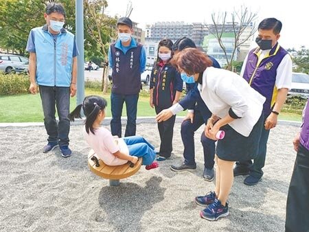 宜蘭縣長林姿妙（白外套）開心地看著李雨蓁玩著「搖搖杯」設施。（胡健森攝）
