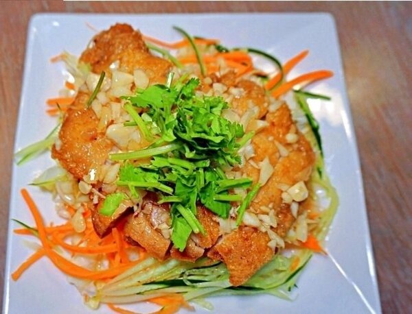 泰式惜食餐廳粩泰泰的招牌料理涼拌香煎雞腿排，選用格外品蔬果製作。圖／新北市農業局提供