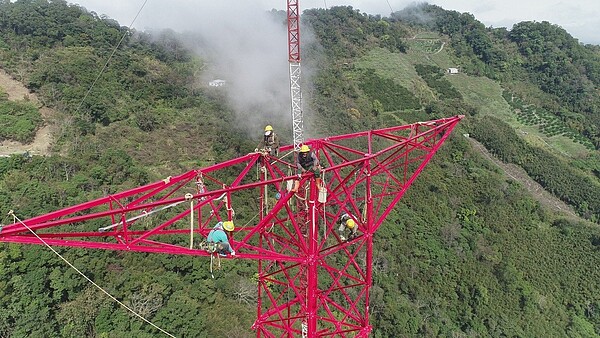 通霄345kV超高壓線路全線共興建65座超高壓鐵塔，圖為輸電線路裝修員正進行鐵塔裝建作業。圖／台電提供