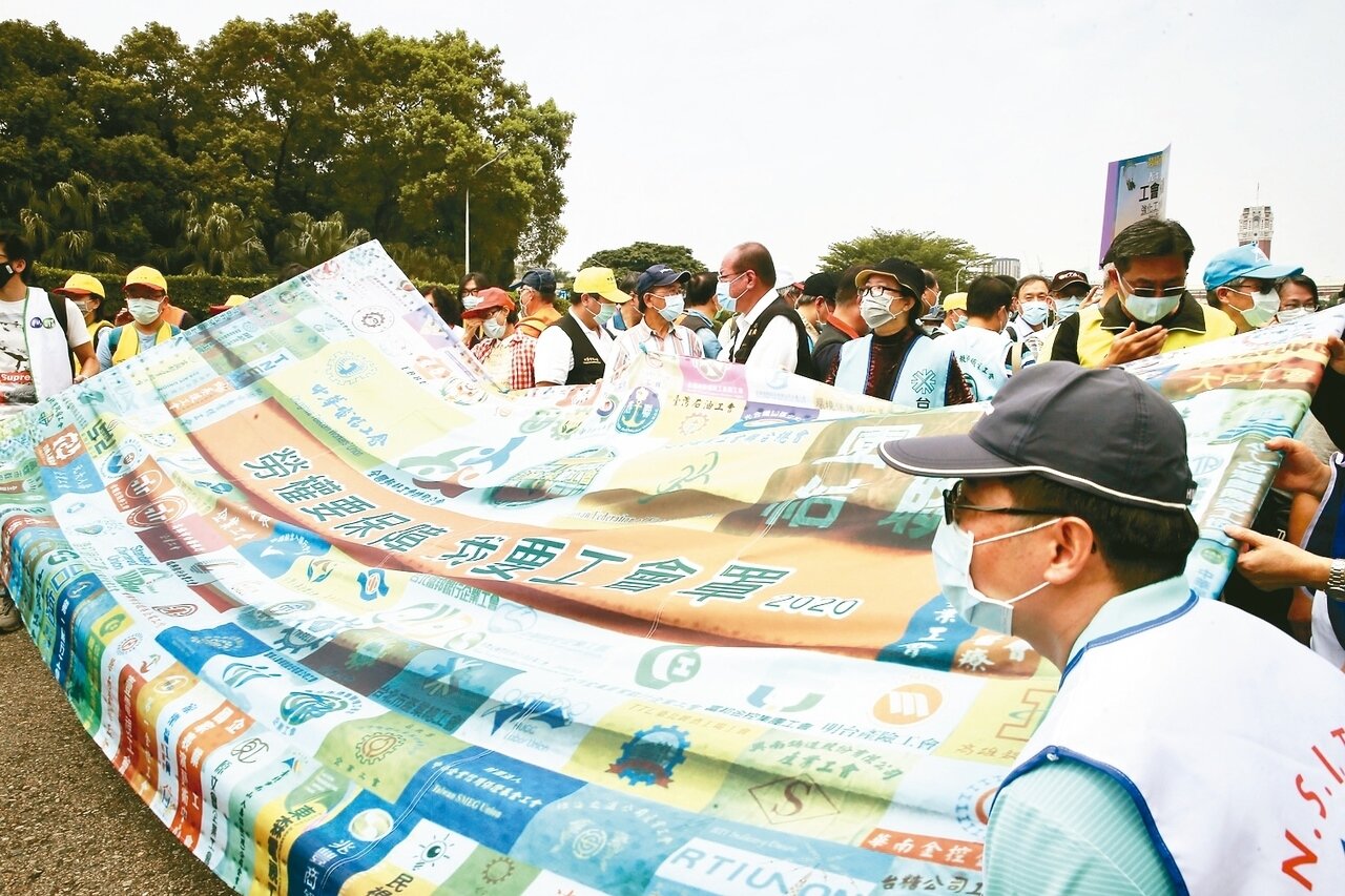 勞團首次取消五一勞動節上街遊行,上午在凱道舉行記者會,現場製作大型口罩表達多項訴求。 記者徐兆玄/攝影