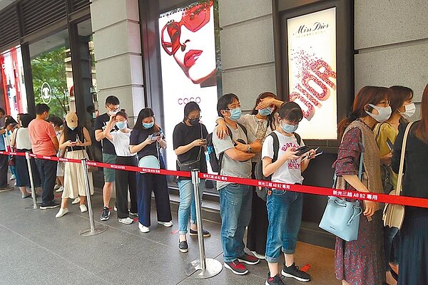 台灣新冠肺疫情趨緩,1日連續第6天零確診,許多民眾趁著五一連假第一天,戴上口罩出遊,到百貨商園逛街,排隊等待進入百貨公司參加活動。(鄭任南攝)