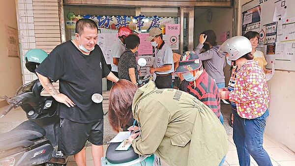 農漁民紓困補助申請昨上路,彰化區漁會王功辦事處擠滿人潮,許多人在辦公室外填寫表格,希望能盡快領到紓困金。記者簡慧珍/攝影