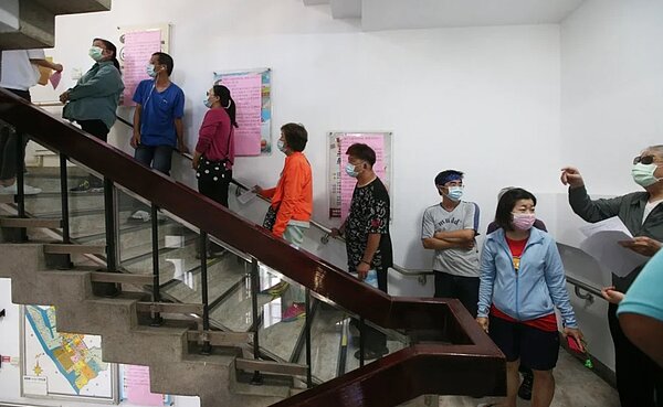 政府祭出紓困金政策,許多民眾近期湧往區公所申請,連樓梯也排了長長人龍。圖/本報系資料照