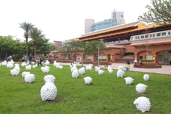 台北捷運淡水站三號出口外即起展出「詩步領羊」藝術展,只要到現場拍下羊咩咩的變裝照,即可抽獎。圖/台北捷運公司提供