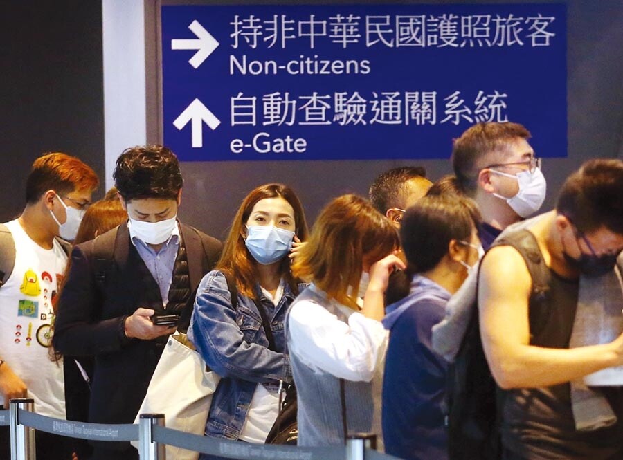 中央流行疫情指揮中心12日宣布,不具本國籍的陸配子女,且目前滯留陸港澳者,一律不予入境,一群外籍旅客12日在桃園機場,準備通關入境。(范揚光攝)