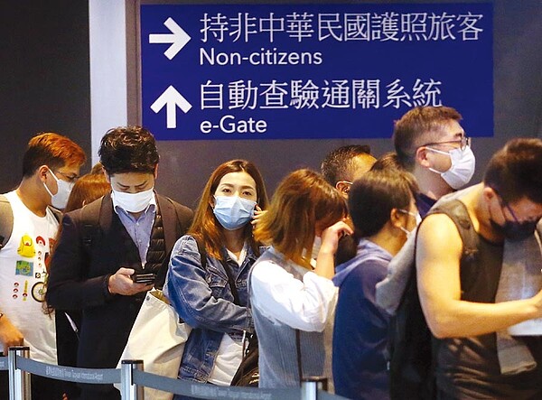 中央流行疫情指揮中心12日宣布,不具本國籍的陸配子女,且目前滯留陸港澳者,一律不予入境,一群外籍旅客12日在桃園機場,準備通關入境。(范揚光攝)