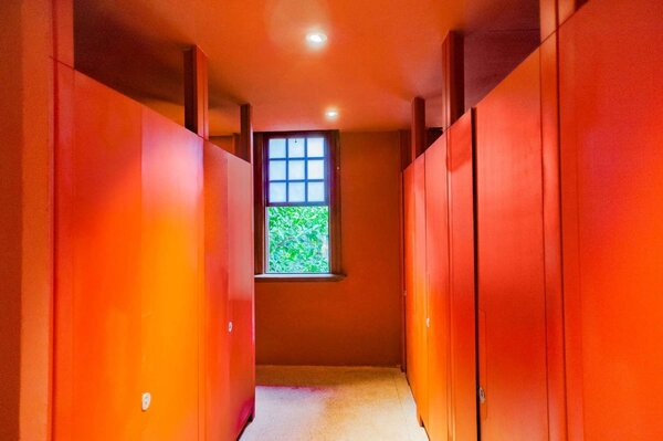 新竹州廳2間廁所近期完成整建，一改過去老舊潮濕，溫暖燈光與磚紅色牆面有如藝展空間。圖／新竹市政府提供