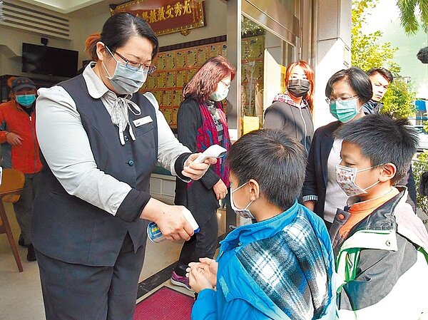 下周就是開學日,但對於體溫量測標準應該是多少,中央流行疫情指揮中心監測應變官莊人祥表示,若使用耳溫槍,發燒標準標準為38度,額溫槍則是37.5度。圖為學童噴酒精消毒手部、並以額溫槍量測體溫。(本報資料照片)