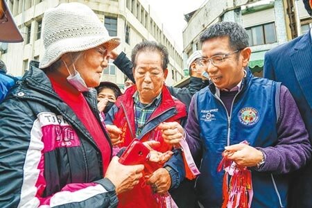 宜蘭市推出「漢方藥材聯名祈福香袋」，宜蘭市長江聰淵（右）23日到市場發放，不到20分鐘就被索取一空。（李忠一攝）