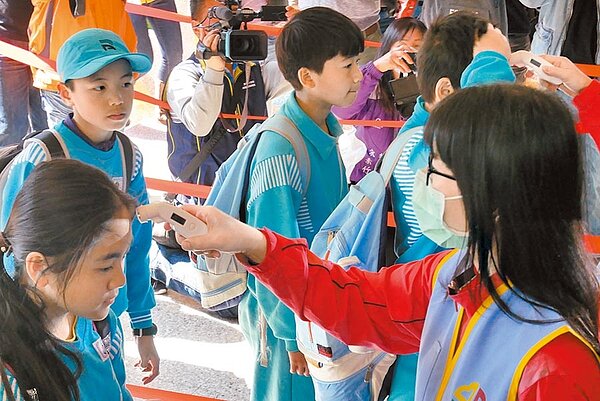 新北市長侯友宜23日視察防疫物資,要求學校防疫務必確實,新北私校卻未被分到額溫槍,引發私校不滿,圖為蘆洲仁愛國小校門口量測照,與新聞事件無關。(戴上容攝)