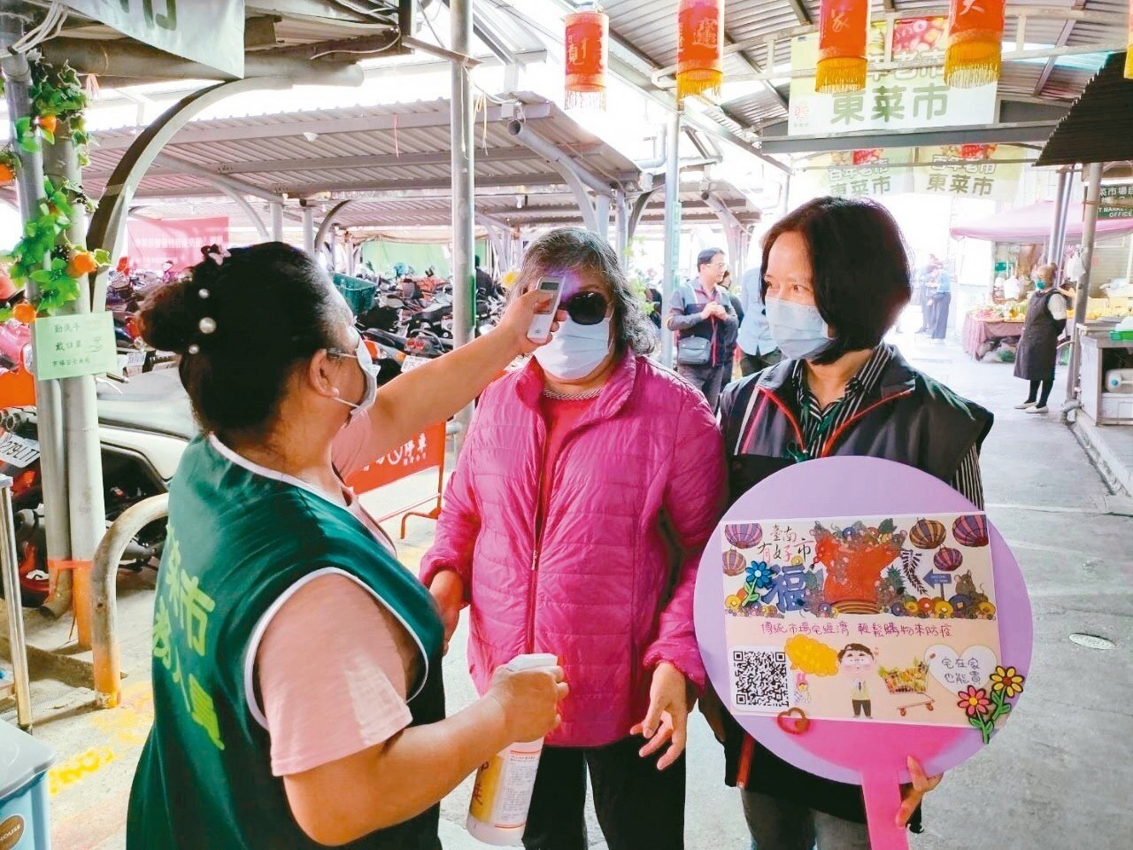 台南市不少市場攤商的生意受到疫情影響,圖為東菜市場為顧客量體溫,希望能增加民眾逛市場的意願。 圖/台南市府提供