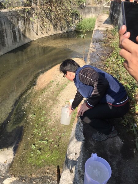 稽查人員在鳳山圳非法排放管線廢水採樣。圖／高雄市環保局提供