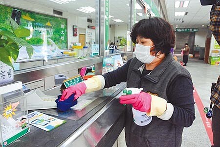 防疫期間,郵局清潔人員,每兩小時會對窗口以及按鍵式機器如提款機擦拭消毒。(王志偉攝)