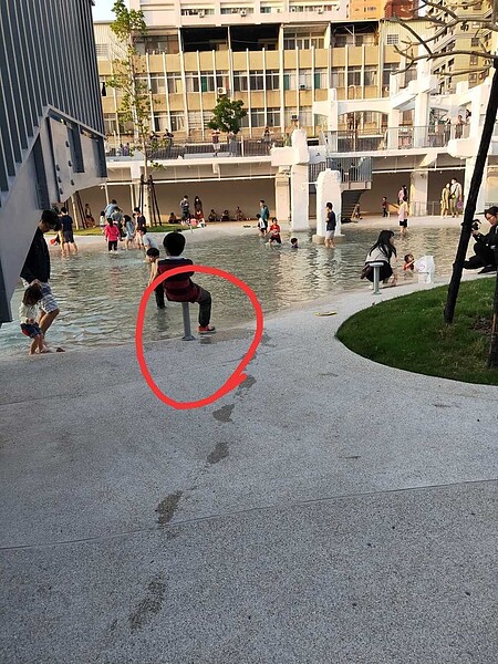 網友在台南市河樂廣場看到有人坐在燈座上,拍照po到台南市長黃偉哲臉書。圖/翻攝自黃偉哲臉書