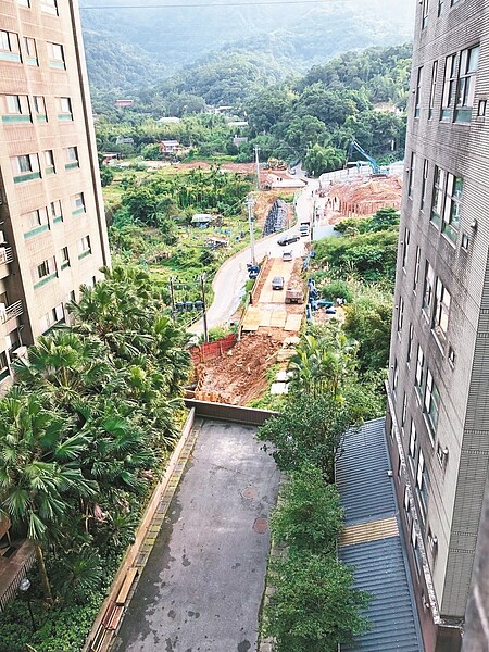 汐止區活力Double社區A、B棟間的道路,後方原有圍牆,建商為開發新案打掉圍牆,並讓大貨車駛過下方掏空做停車場的道路。 圖/活力Double社區管委會主委許志明提供