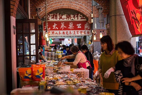 迪化街商圈走過百年的歷史，留下了紅磚洋樓、閩南式的矮房建築，是中藥、南北貨和布行的集散地，融合風格迥異的百年建築與新興文創小店，在新舊交融中散發獨有的生命力。