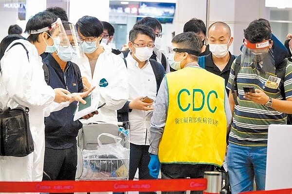 本月22日起,開放11國或地區等中低感染風險的外籍旅客短期商務入境。圖為昨日桃機入境旅客依規定接受檢疫官審查入境資料。(陳麒全攝)