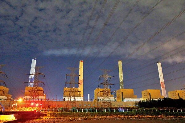 不顧許可證遭廢及市府抗議,台電中火2號機組昨晚間點火,預料將再掀中央地方大戰。圖為24日晚間中火招牌煙囪冒出些許白煙。(黃國峰攝)