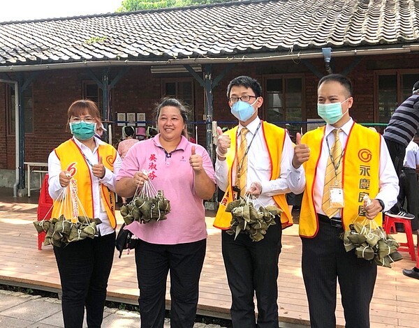 永慶房屋萬大店同仁與中正區和平里里長吳淑芬開心包粽。圖／永慶房產集團提供