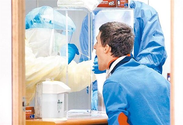 台大醫院兒童感染科主任黃立民表示,台灣可考慮實施邊境普篩政策,否則社區感染的壓力將增加。圖為1名剛入境的旅客正在採集檢體。(本報資料照片)