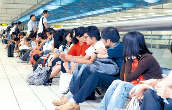 往年萬安演習警報後人車管制，捷運站內旅客被管制在站內不得出站，只好就地坐在護欄邊等待演習結束。記者游順然／攝影 