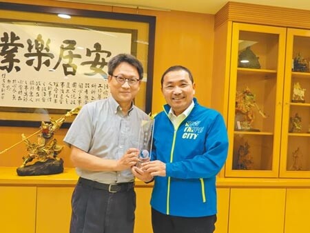 新北市長侯友宜滿意度獲六都第一,台灣世界新聞傳播協會長劉立漢(左)15日頒發獎牌給侯友宜。(葉德正攝)