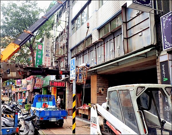 拆除大隊出動人力機具拆除板橋區文化路1段243號前傾頹的廣告招牌。圖/新北市政府提供