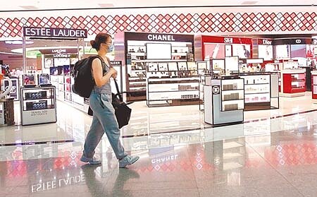 行政院會23日通過「紓困3.0」方案,並追加預算新台幣2100億元,國際機場商業服務設施業也在補助之列,在桃園機場的出境管制區內,旅客走過空蕩蕩的免稅店。(范揚光攝)