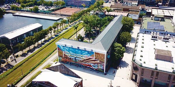 使用樓地板面積約972坪的高雄港灣「候工室」舊址(有彩繪牆的中間建物),將調降旅宿營業比例之後,重新招商。圖/土開公司提供