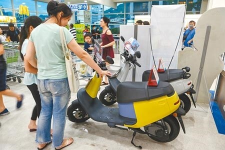 財政部表示,車輛移動汙染源是造成台灣空汙主因之一,因此必須負擔貨物稅,引爆機車族怒火,紛紛上網開嗆。圖為大賣場內擺了兩部電動機車,逛街民眾不免多看幾眼。(本報資料照片)