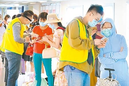 中央流行疫情指揮中心宣布,7月16日起優先開放國人2歲以下持居留證的陸籍子女申請入境,入境後依規定14天居家檢疫。圖為16日下午入境旅客在通關前,由疾管局協勤人員檢查填寫的相關入境檢疫資料。(陳麒全攝)