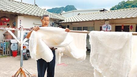 泉明生態教育蠶業農場負責人涂泉明,用手拉扯真蠶絲說明延展性。(巫靜婷攝)