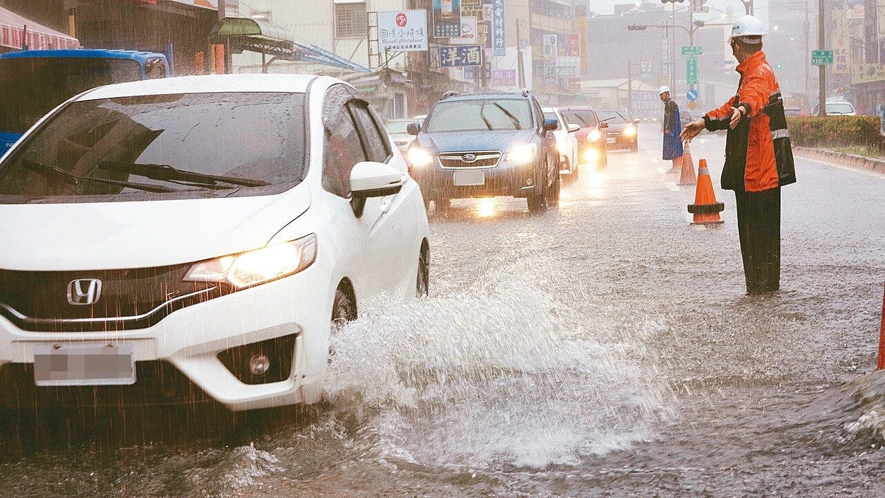 高雄市區上午降下豪大雨，造成許多路面積水，楠梓右昌路一帶積水嚴重，車輛都要涉水而過。記者劉學聖／攝影