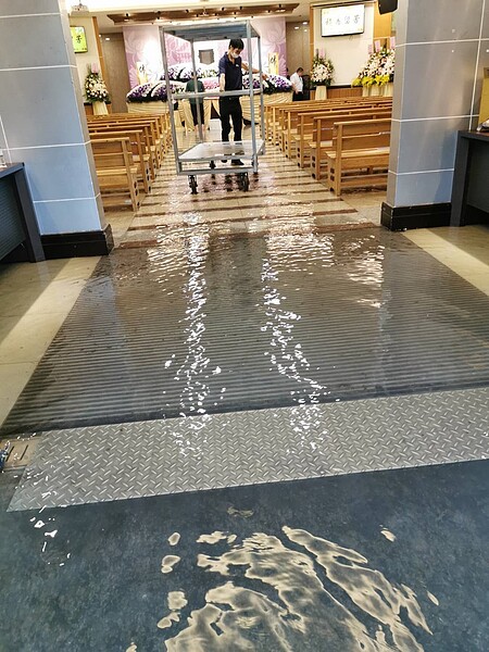 台北市下午的大雨一度造成第二殯儀館積水,影響喪家公祭,經過殯葬處動用沙包和抽水機,公祭才得以進行。圖/ 議員秦慧珠提供